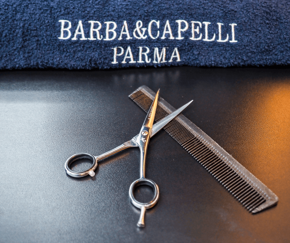 asciugamano-firmato-barba-e-capelli-parma-con-accanto-strumenti-da-barbiere-forbici-e-pettine