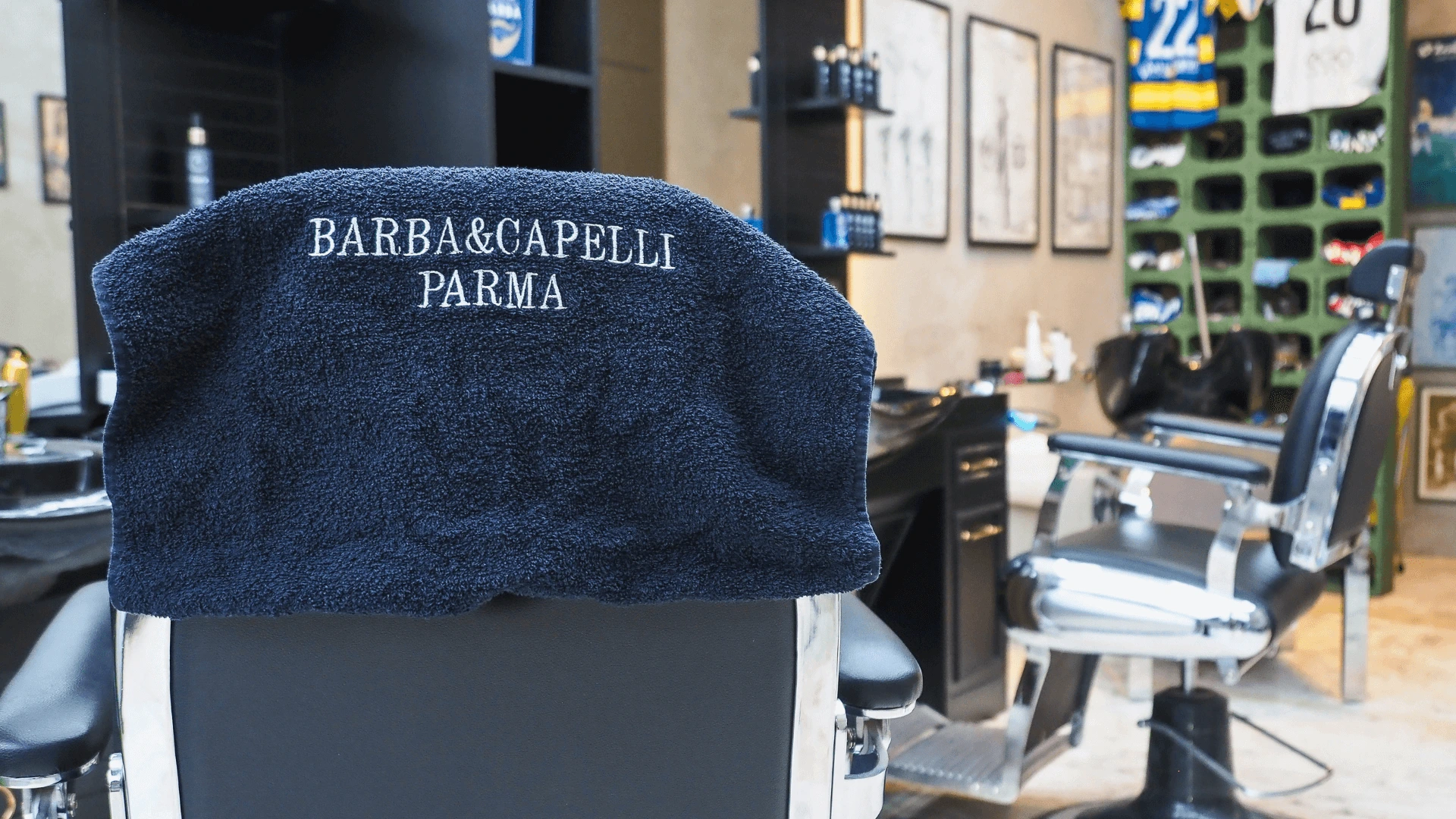 asciugamano-firmato-barba-e-capelli-parma-posto-su-una-poltrona-sullo-sfondo-la-barberia