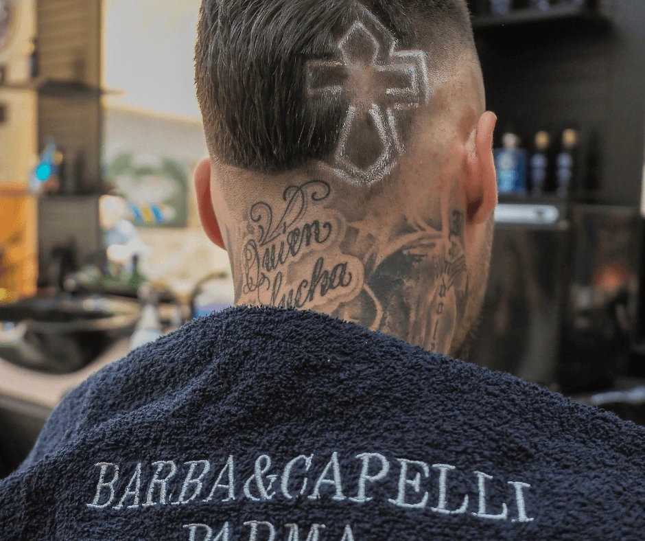 taglio-moderno-con-croce-disegnata-a-parma-da-barba-e-capelli-con-asciugamano-firmato-con-il-nome-della-barberia-a-parma