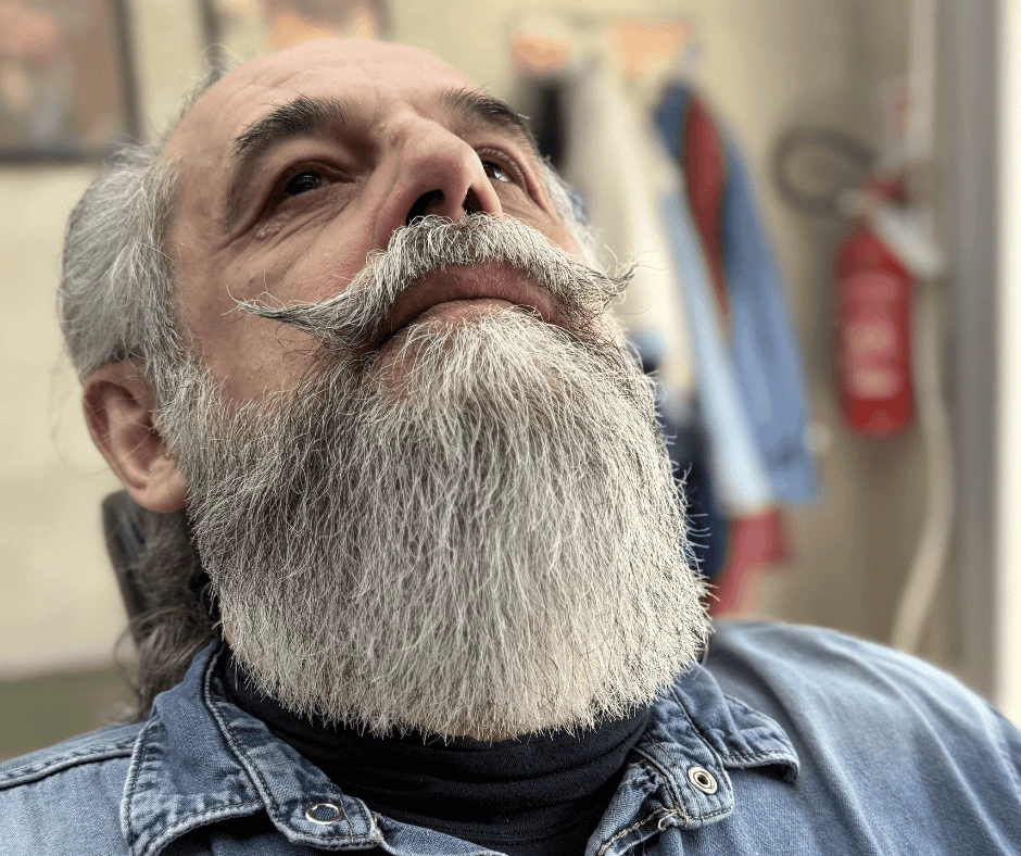 Cliente con barba lunga bianca e baffi a manubrio modellati